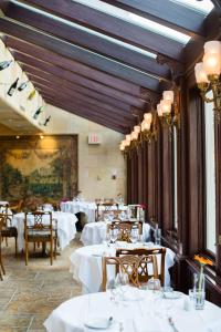 a dining room with white tables and chairs at Prince of Wales in Niagara on the Lake