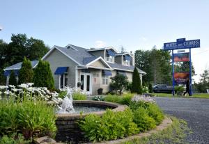 a house with a fountain in the middle of a street at Motel des Cèdres in Sherbrooke