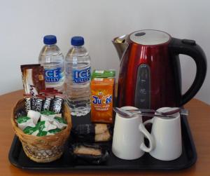 a tray with a tea kettle and drinks and snacks at Apollo Guest House in Hastings
