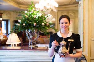 une femme qui donne un pouce en tenant un trophée dans l'établissement Prince of Wales, à Niagara on the Lake