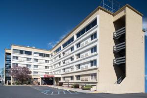 a large white building with a parking lot at Ramada by Wyndham Downtown Spokane in Spokane
