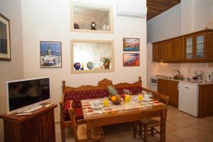 a kitchen with a table and a television in a room at Enatha in Argyroupolis