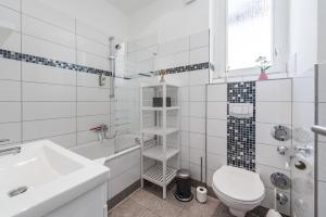 ein weißes Badezimmer mit Toilette und Waschbecken in der Unterkunft Family-Apartments Freiburg in Freiburg im Breisgau + 31 Fotos