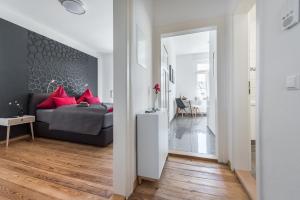 ein Schlafzimmer mit einem Bett mit roten Kissen in der Unterkunft Family-Apartments Freiburg in Freiburg im Breisgau
