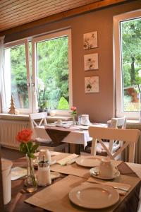 comedor con mesa y 2 ventanas en Pension Trautheim - Am Stadtpark, en Bad Harzburg