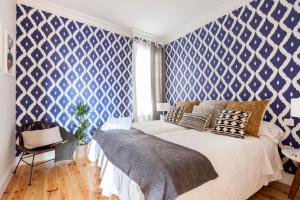a bedroom with blue and white wallpaper and a bed at Casa Malasaña in Madrid