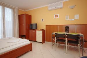 1 dormitorio con 1 cama, mesa y sillas en Várárok Apartman, en Gyula