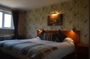 1 dormitorio con 1 cama y una pintura en la pared en Orchard Lodge & Wolds Restaurant en Scarborough