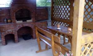 un patio con chimenea de ladrillo y banco de madera en Casa Neluta, en Haţeg