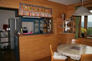 a kitchen with a table and a refrigerator at Azumino Backpackers 山の風 in Matsukawa