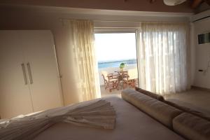 Un dormitorio con una cama y vistas a la playa. en Nefeli Apartments, en Sarandë