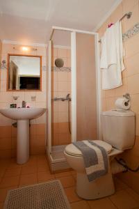 a bathroom with a toilet and a sink and a shower at Enatha in Argyroupolis