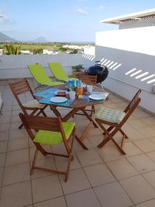 a table and chairs on a balcony with a meal on it at Residence Ciel Bleu in Flic-en-Flac