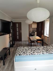 a living room with a bed and a dining room table at Apartament Pocztowa in Drawsko Pomorskie
