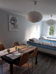 ドラフスコ・ポモルスキエにあるApartament Pocztowaのダイニングテーブルとベッドが備わる客室です。