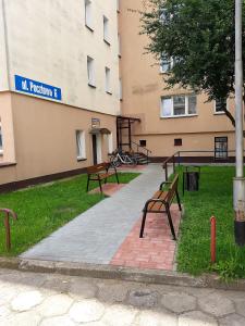 two benches sitting in front of a building at Apartament Pocztowa in Drawsko Pomorskie