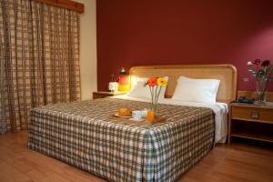 Ribeirotel في البرغاريا-ا-فلهه: غرفة في الفندق مع سرير مع صينية عليها زهور