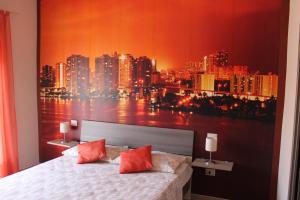 a bedroom with a large painting of a city skyline at B&B Around the World in Villa San Giovanni