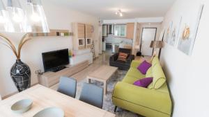 a living room with a yellow couch and a table at Nora Nice in Moraira