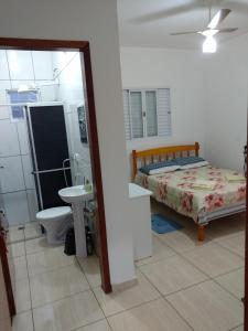 a bedroom with a bed and a bathroom with a sink at Pousada LM in Nova América da Colina