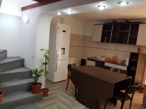 a kitchen and dining room with a table and a refrigerator at Casa DeLux in Băile Olăneşti