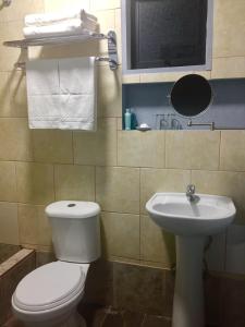 a bathroom with a white toilet and a sink at Maromava Patagonia in Puerto Natales