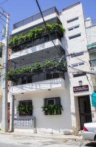 a white building with plants on the balconies at Villago Residences in Santo Domingo
