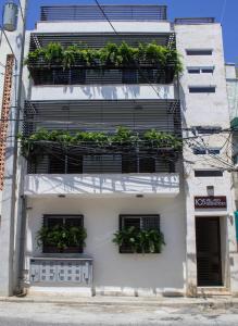 a white building with plants on the balconies at Villago Residences in Santo Domingo
