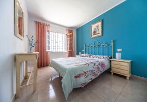 a bedroom with a bed and a blue wall at Apartamento Marina in Puerto del Carmen