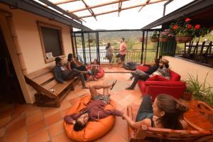 people sitting on a couch in a living room at Lake View Hostel in Guatapé