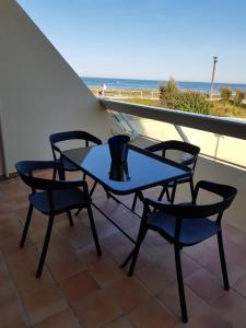 d'une table et de chaises sur un balcon avec vue sur la plage. dans l'établissement Studio Naturiste "AZUR" Héliopolis C 64, au Cap d'Agde