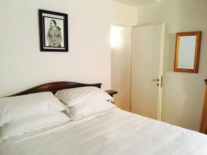 ミラノにあるSUITE (bedroom & living room)のベッドルーム1室(白いシーツと鏡付きのベッド1台付)