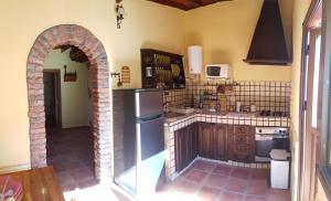 a kitchen with a refrigerator and an archway at Casa Rural Vicente in Vallehermoso