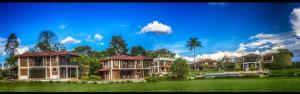 un groupe de maisons dans un champ verdoyant planté d'arbres dans l'établissement Finca Hotel Casa Nostra, Villa Manuela, à Quimbaya