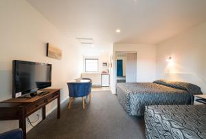 a hotel room with two beds and a television at Annabelle Court Motel in Christchurch