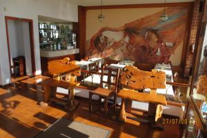 una stanza con tavoli e sedie in legno e un quadro di Hotel Carilo a Mar del Plata
