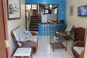 a living room with chairs and a table and a kitchen at Excelente Casa Duplex in Aquiraz