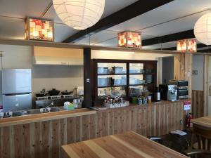 a kitchen with a table and a counter with a refrigerator at B&B Neagari in Nomi