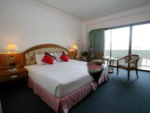 a hotel room with a large bed and a window at Hatyai Merridian Hotel in Hat Yai