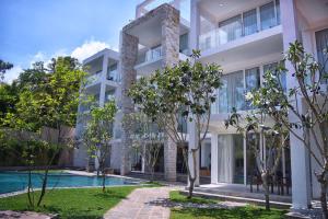 an apartment building with a swimming pool and trees at Triple O Six in Mirissa