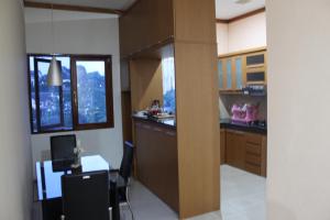 a large kitchen with a desk and a window at De Hill Villa in Bandung