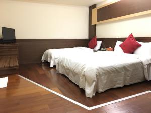 a hotel room with two beds with red pillows at Fu Chang Hotel in Taipei