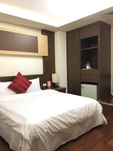 sypialnia z dużym białym łóżkiem z czerwoną poduszką w obiekcie Fu Chang Hotel w Tajpej