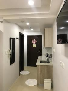 a kitchen with a sink and a black door at Umali Kayo at Megatower Residences II in Baguio