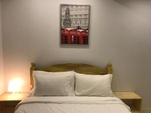 a bedroom with a bed with a picture on the wall at Umali Kayo at Megatower Residences II in Baguio