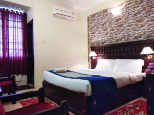 Un dormitorio con una cama y una pared de ladrillo. en Hotel Palace Tower, en Trichūr 11 fotos más