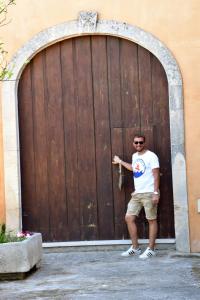 NocigliaにあるVilla Monticelliの大きな木の扉前に立つ男