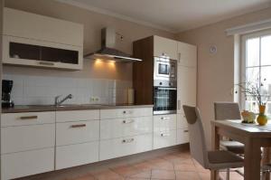 a kitchen with white cabinets and a table and a sink at Strandvilla Kalifornien direkt am Meer in Kalifornien