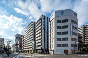 un edificio blanco alto en la esquina de una calle en Hotel Route-Inn Tokyo Kamata en Tokio