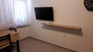 a living room with a television on a wall at Nora Apartments in Povljana